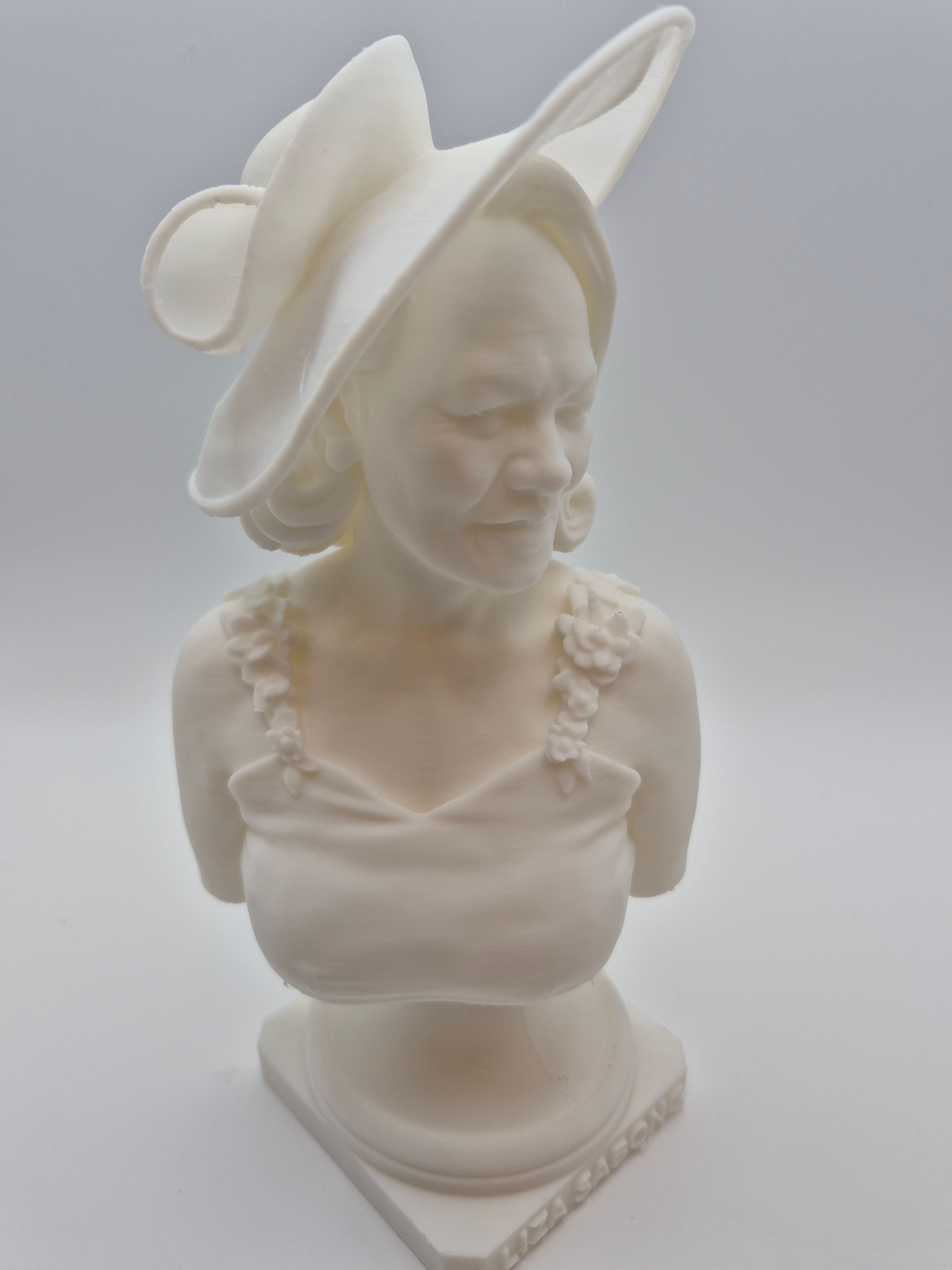 White plastic sculpture of a woman's head on a plain background